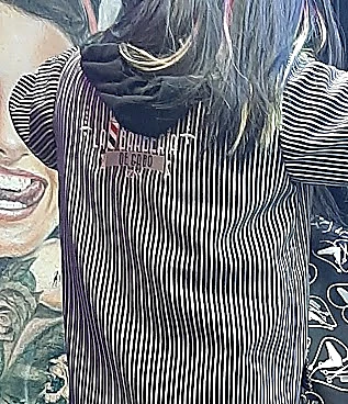 Espalda de la camisola de rayas negras y blancas del equipo con el logo de La Barbería de Gabo